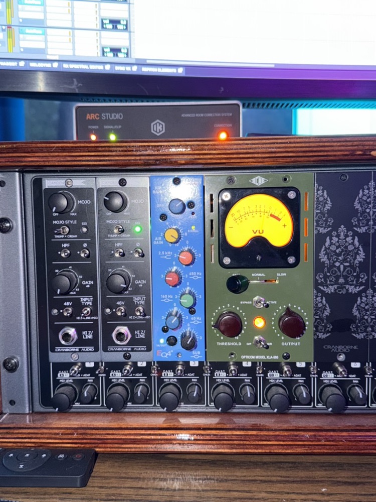 The full 500-series rack in the desk, with the session running on the screens above.